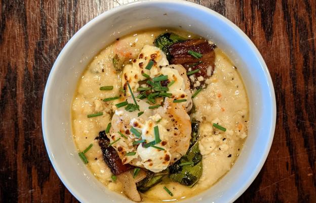 Shrimp Polenta with pan seared garlic and wine shrimp, peppadew peppers, capers, garlic, shallots, aParmesan cheese, arugula, creamy polenta, and served with our bacon and sauteed onion collard greens.