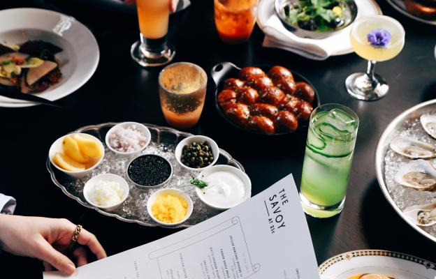 A full table of food and drinks with a restaurant menu.