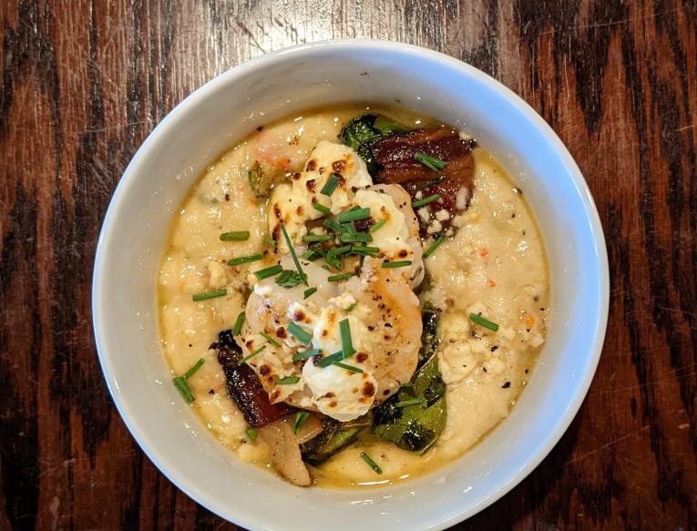 Shrimp Polenta with pan seared garlic and wine shrimp, peppadew peppers, capers, garlic, shallots, aParmesan cheese, arugula, creamy polenta, and served with our bacon and sauteed onion collard greens.